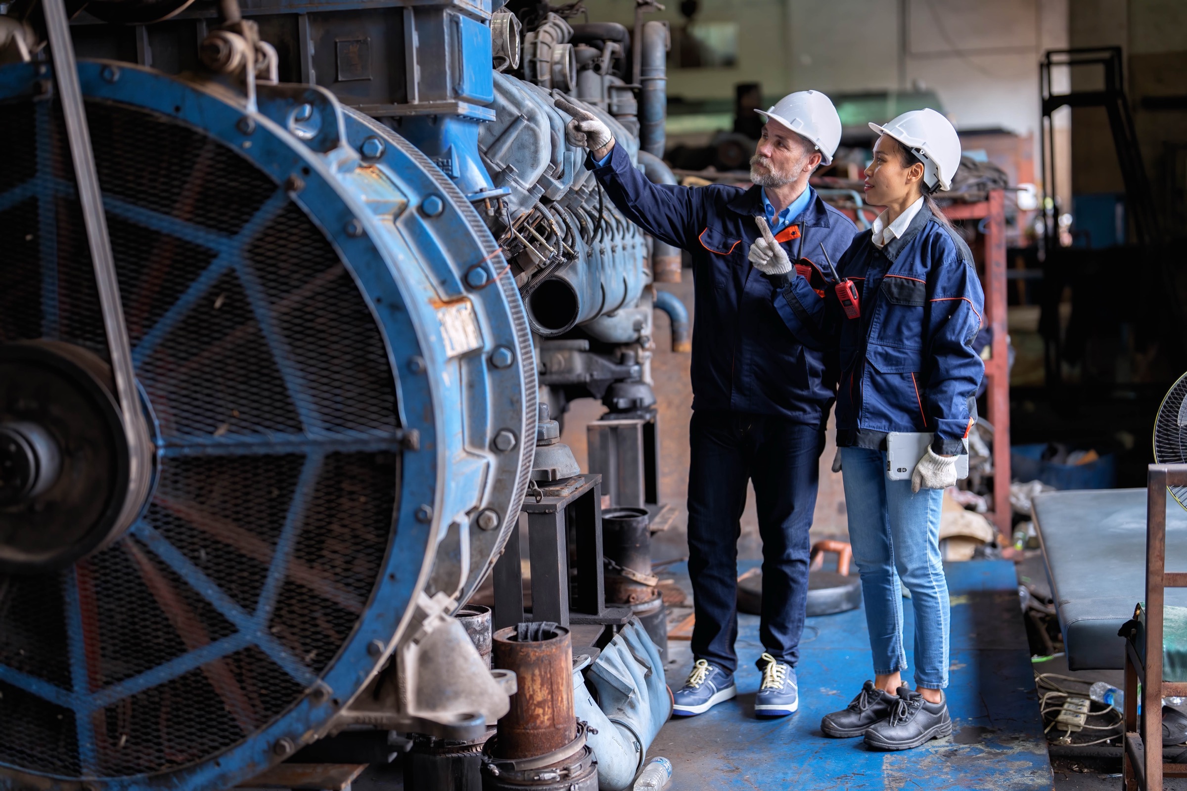 Maintenance engineers inspecting heavy industrial machinery